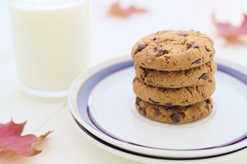 Milk and cookies in stack with seasonal decoration fall leaves