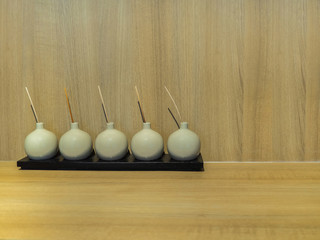 Rounded bottles contain deodorant perfume on black wooden plate