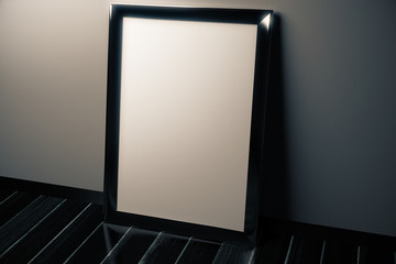 Blank picture frame on black floor in empty room, mock up