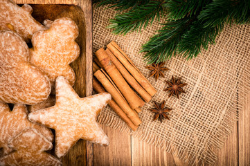 Christmas decorative composition - gingerbread with cinnamon, anise on the wooden background.