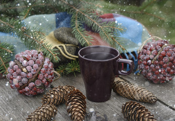 Сup of hot tea on a rustic wooden table. Still life of cones, twine, patskthread, fir branches....