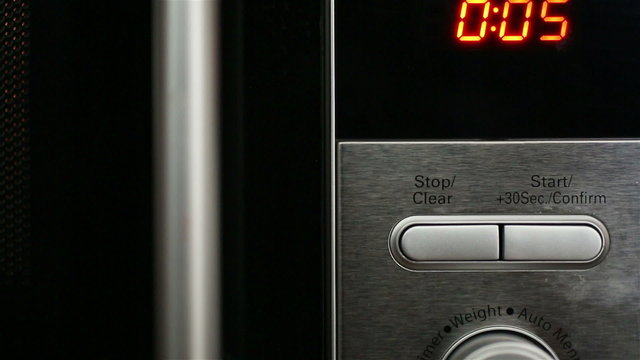 Modern and stylish detail of microwave clock counting down from ten seconds in a kitchen
