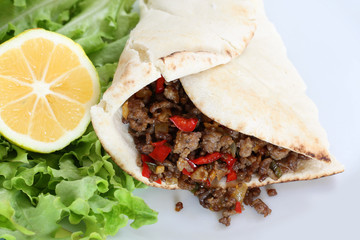 healthy eating: grilled beef taco with vegetables, salad and lemon served on plate