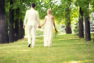Fototapeta premium bride and groom walk in the woods