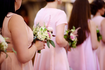 Obraz na płótnie Canvas Row of bridesmaids with bouquets at wedding