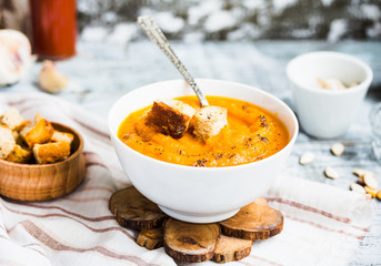 Pumpkin soup with carrots, croutons in a white dish, vegetarian,