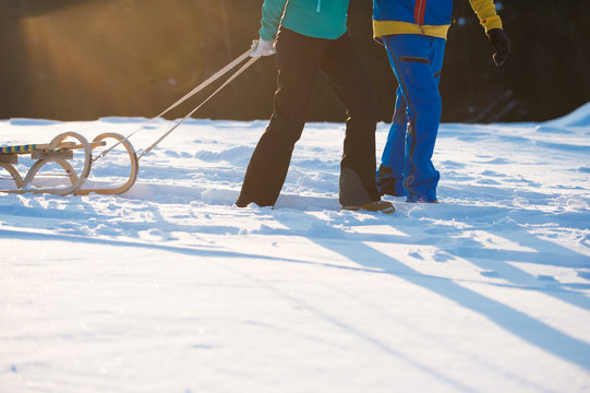 Junges Paar beim Schlittenfahren im Winter