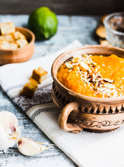 Pumpkin soup with carrots and homemade croutons in clay pots, ru