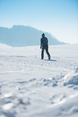 Junger sportlicher Mann beim Langlaufen im Winter