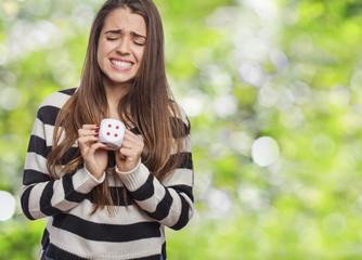 Young sad and unfortunate woman holding dice