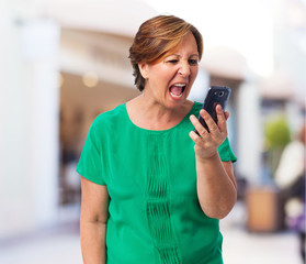 portrait of angry mature woman talking on telephone