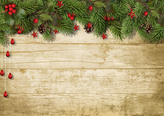 Christmas fir branches and holly on wood background