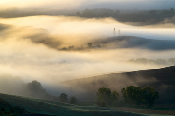 Gra światła we mgle zalewającej dolinę,Toskania