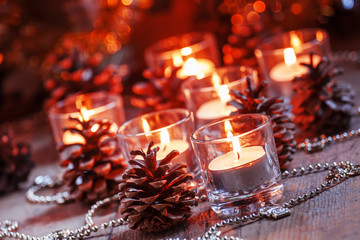 Christmas and New Year's background with candles, fir cones and