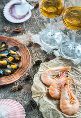 Fototapeta na wymiar Seafood with two glasses of white wine on the wooden table
