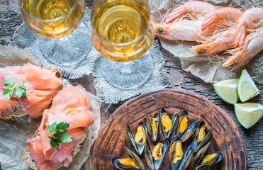 Seafood with two glasses of white wine on the wooden table