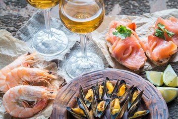 Seafood with two glasses of white wine on the wooden table