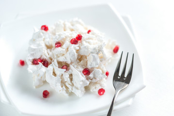 Portion of meringue with pomegranate seeds
