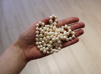 жемчужные бусы на вытянутой ладони