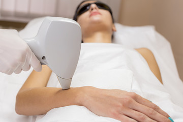 Laser hair removal on client hand in beauty salon