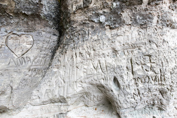 sandstone cliff wall with inscriptions