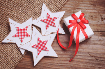 Christmas stars and gift box decoration on wooden background