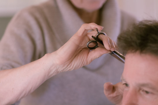 close up of hairdersser cutting senior man's hair