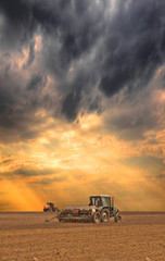 Fototapeta premium Tractors seeding the field