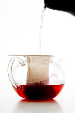 Teekanne aus Glas mit Teefilter, Tee aufbr&uuml;hen, zubereiten, hei