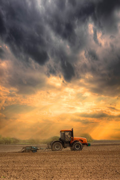 Fototapeta Tractor cultivating the field
