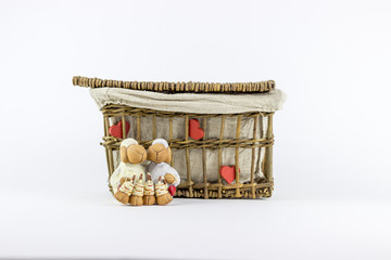 Two sheep figurines in front of a vintage rattan basket