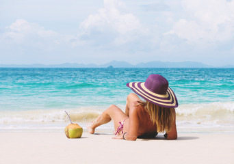 Fototapeta na wymiar Happy young woman in straw hat with on the beach