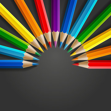 Semicircle of rainbow colored pencils with realistic shadow on dark grey background