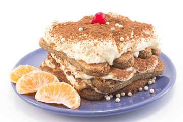 Tiramisu decorated with tangerines, beads and candied cherry