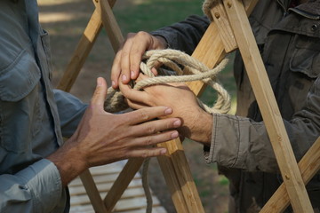 Hands of male builders. Men build Asian yurt frame.