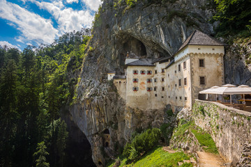 Fototapeta na wymiar Renaissance Castle Built Inside Rocky Mountain in Predjama, Slovenia. Famous Tourist Place in Europe.
