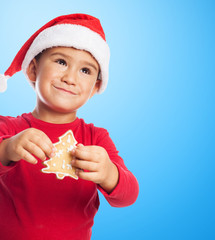 portrait of a little boy holding a christmas cookie