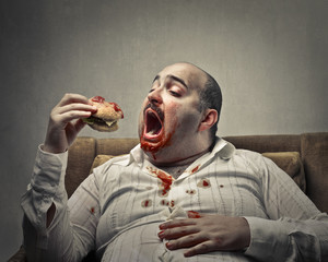 Voracious man eating a hamburger