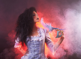 Beautiful Halloween vampire woman aristocrat with venetian mask