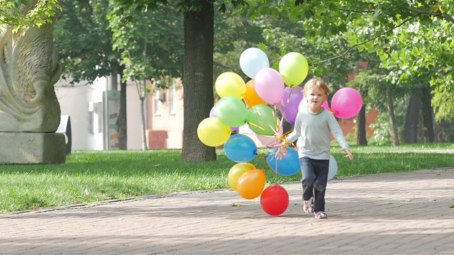 emotional little girl runs with multicolored balloons, Slow motion