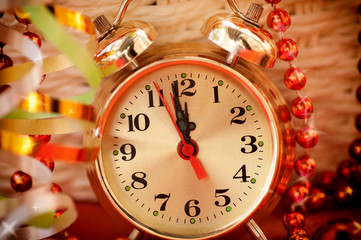 Obraz na płótnie Canvas watch hands by 12 hours and Christmas toys background closeup