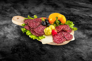 Salami sausage slice and vegetables on wooden board with clippin