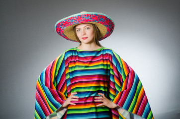 Girl in mexican vivid poncho against gray