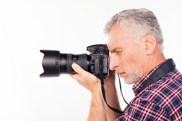Side view of aged photographer making a photo