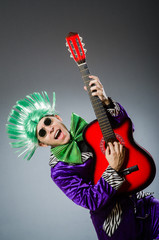Fototapeta premium Funny man playing guitar in musical concept