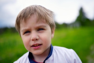 Outdoors closeup portrait of caucasian little boy