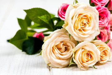roses on white wooden planks background. flowers