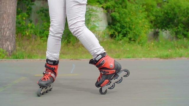 Legs of a woman roller skating backwards and turning to forward in slow motion 