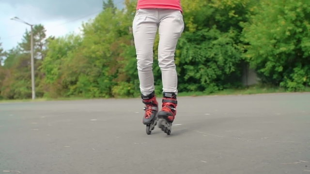 Low section of a woman doing a spin on inline skates in slow motion