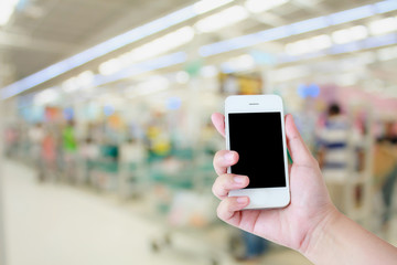 Hand use smartphone with Supermarket store background ,Cashier c
